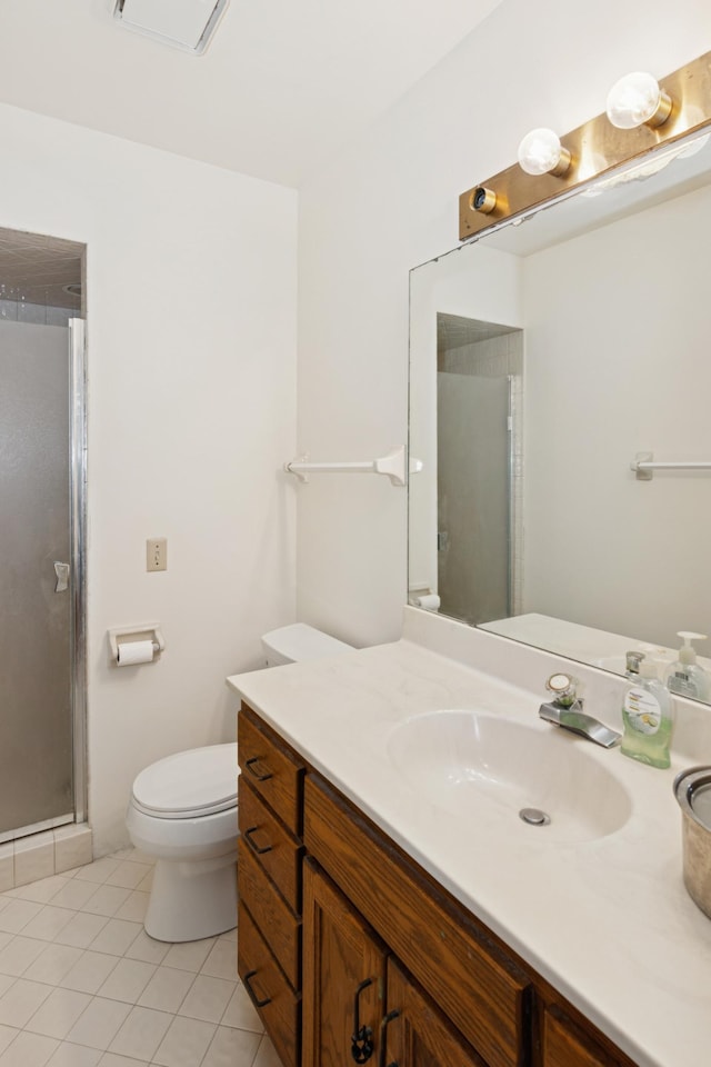 bathroom featuring tile patterned flooring, a shower stall, toilet, and vanity