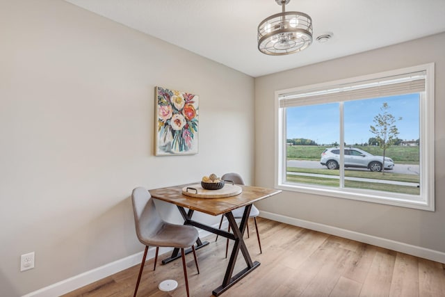 dining area featuring light wood-type flooring and baseboards