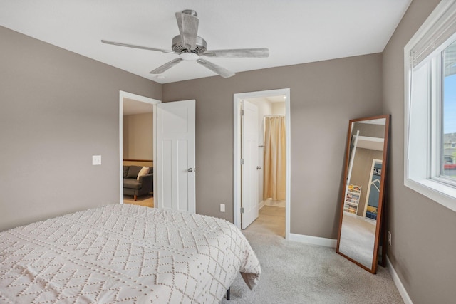 bedroom featuring a ceiling fan, light carpet, connected bathroom, and baseboards