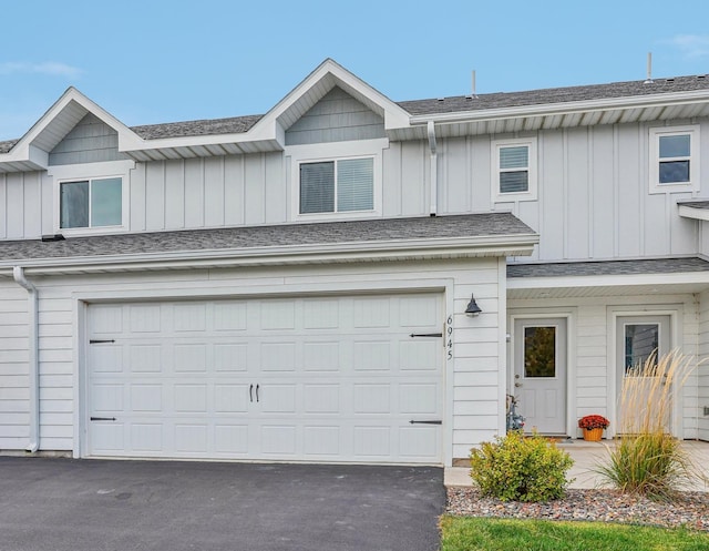 view of front of property with a garage, a shingled roof, aphalt driveway, and board and batten siding