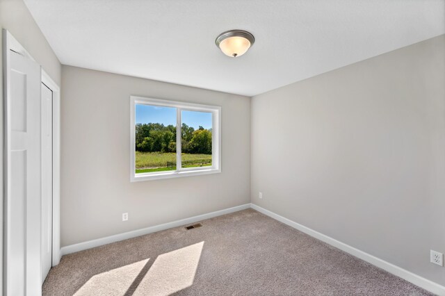 unfurnished bedroom featuring carpet flooring, visible vents, and baseboards