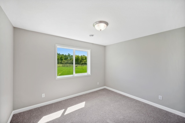 carpeted spare room featuring baseboards