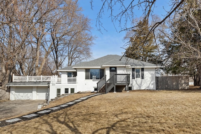 view of front of home with aphalt driveway, fence, a front lawn, and a shingled roof