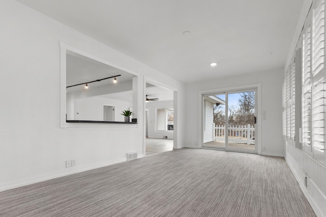 unfurnished room featuring track lighting, visible vents, carpet floors, and ceiling fan