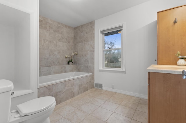 full bathroom with tile patterned floors, toilet, tiled tub, and visible vents