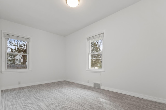 spare room featuring visible vents, baseboards, and carpet