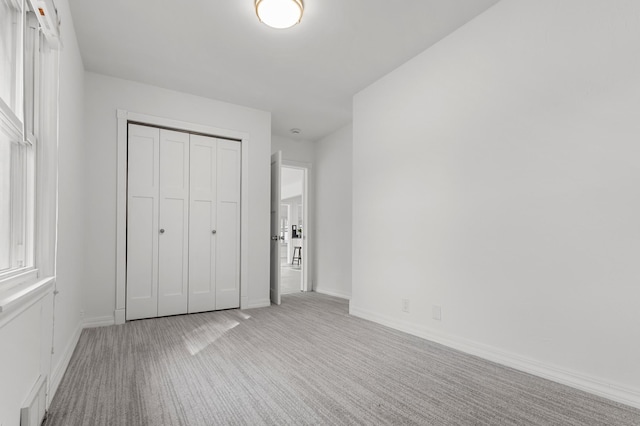 unfurnished bedroom featuring visible vents, baseboards, a closet, and carpet floors