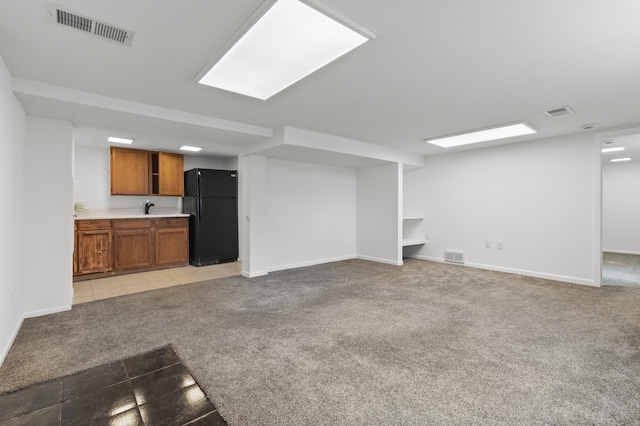 unfurnished living room with visible vents, baseboards, light colored carpet, and light tile patterned flooring