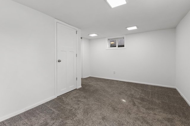 finished basement featuring baseboards and dark colored carpet