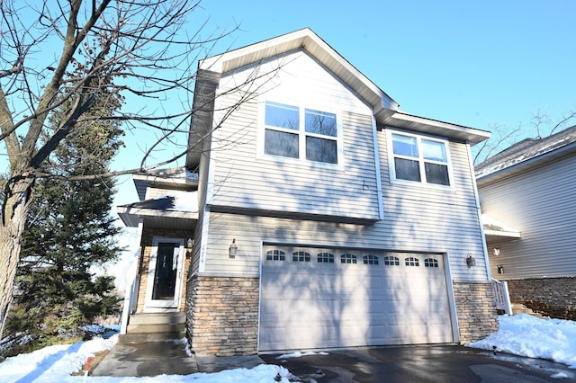 view of front facade with a garage, stone siding, and driveway