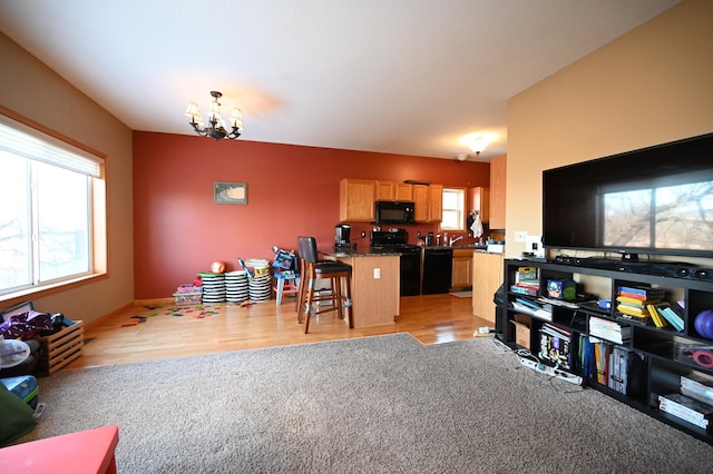 living room featuring light carpet, light wood-style flooring, and a chandelier