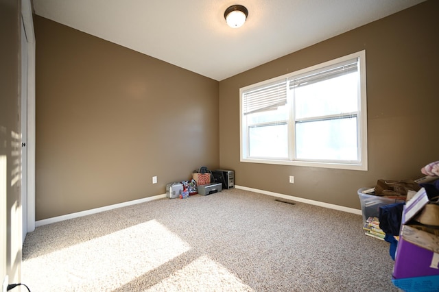 interior space with visible vents, lofted ceiling, carpet, and baseboards