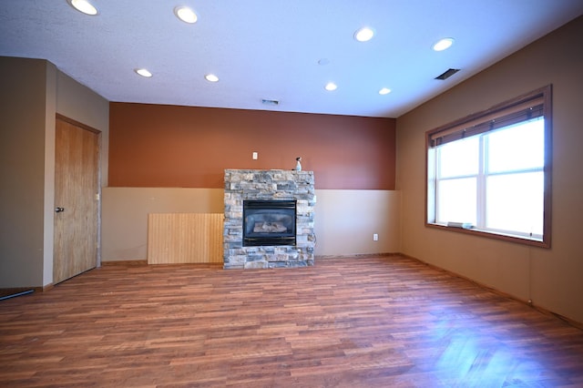 unfurnished living room with visible vents, recessed lighting, a fireplace, and wood finished floors