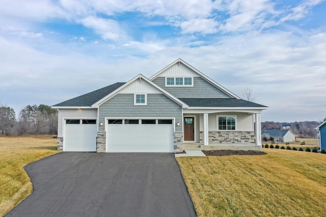 craftsman-style house featuring stone siding, a front lawn, a porch, and aphalt driveway