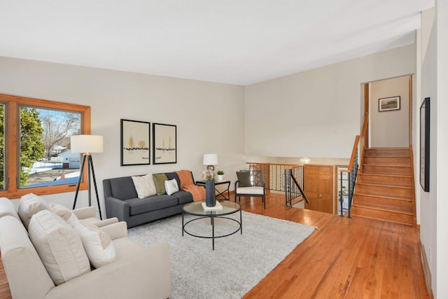 living room with stairs and wood finished floors