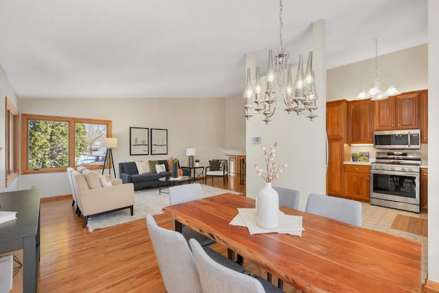 dining space with a notable chandelier, light wood-type flooring, and lofted ceiling