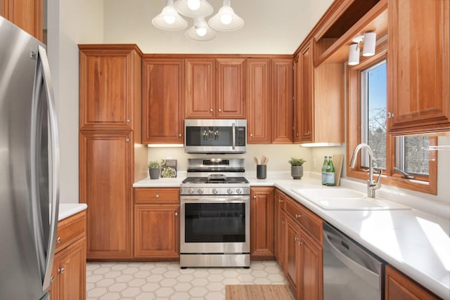 kitchen with a sink, light countertops, brown cabinetry, and stainless steel appliances