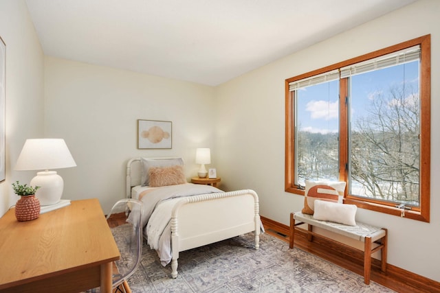 bedroom featuring baseboards and wood finished floors