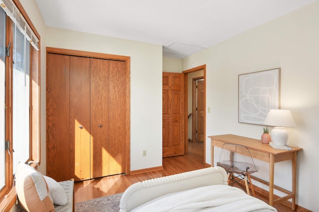 bedroom with a closet, baseboards, and wood finished floors