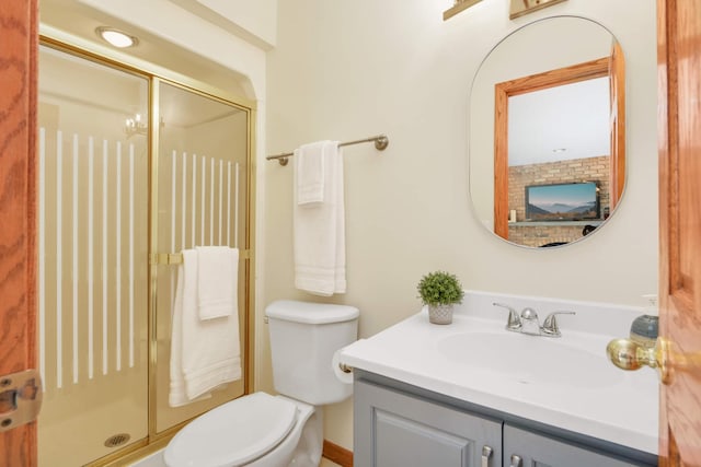 bathroom featuring vanity, toilet, and a stall shower