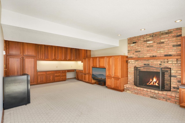 living room featuring recessed lighting, a fireplace, built in desk, and light carpet