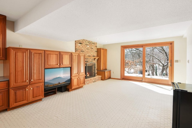 living room with light colored carpet, a brick fireplace, a textured ceiling, and baseboards