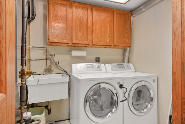 clothes washing area with washer and dryer and cabinet space