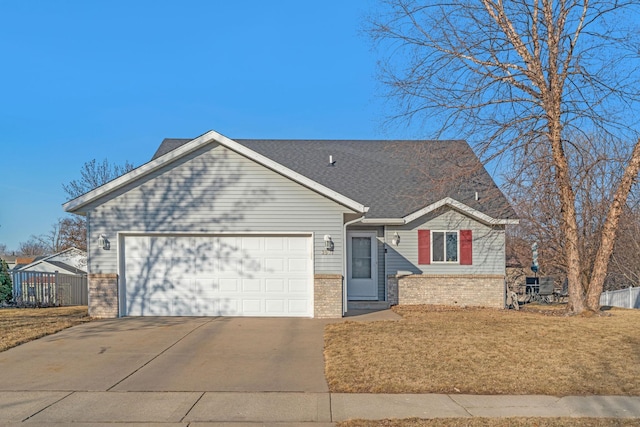 view of front of home featuring driveway, a front lawn, roof with shingles, a garage, and brick siding