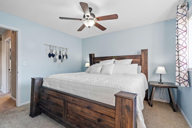 bedroom with light colored carpet, baseboards, and ceiling fan