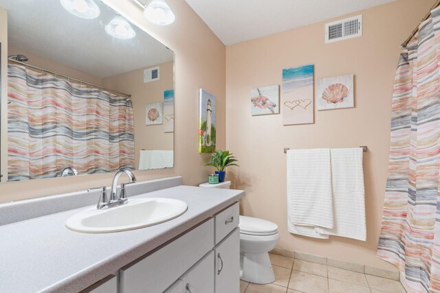 bathroom featuring visible vents, toilet, vanity, and tile patterned flooring