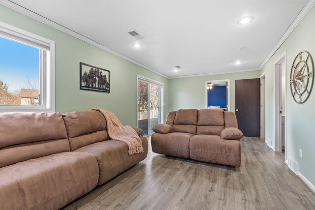 living room with visible vents, ornamental molding, recessed lighting, light wood-style floors, and baseboards