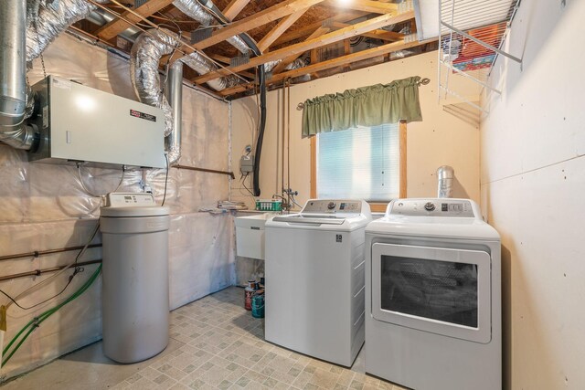 clothes washing area featuring a sink, laundry area, and washer and clothes dryer