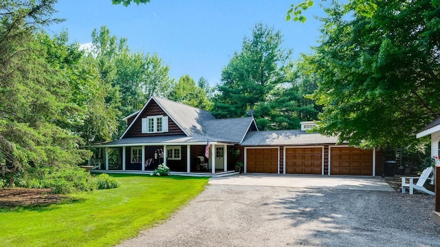 view of front of home with a garage, a front yard, covered porch, and driveway