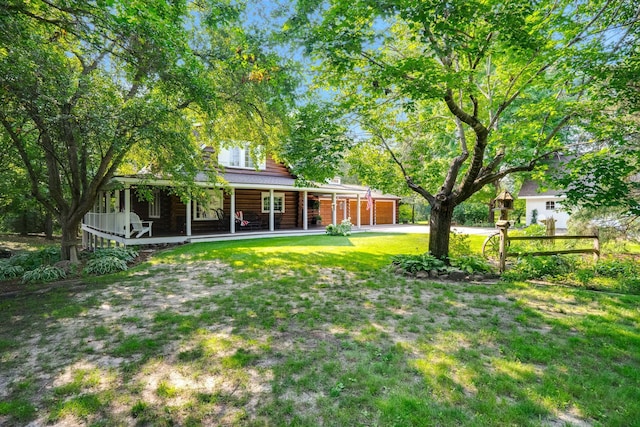 view of yard with a porch and driveway