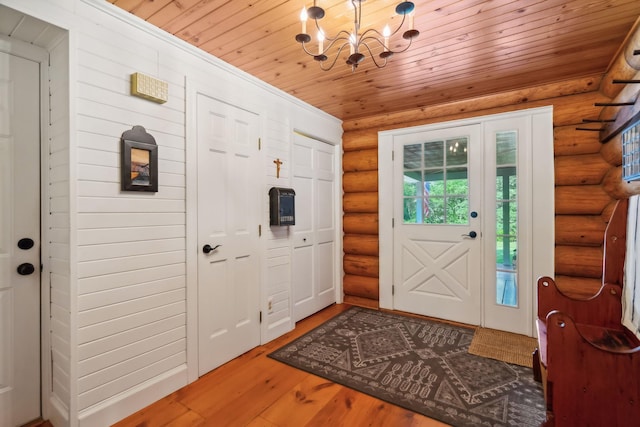 entrance foyer with wooden ceiling, log walls, an inviting chandelier, and wood finished floors