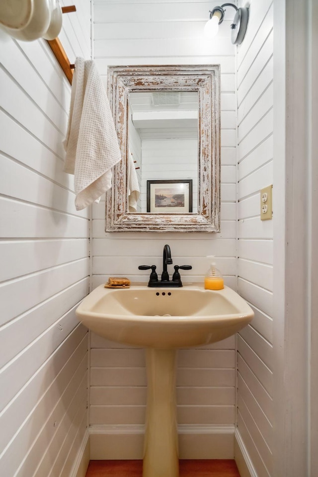 bathroom featuring wooden walls