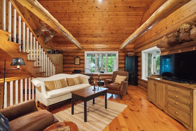 living area with stairs, high vaulted ceiling, light wood-type flooring, and log walls