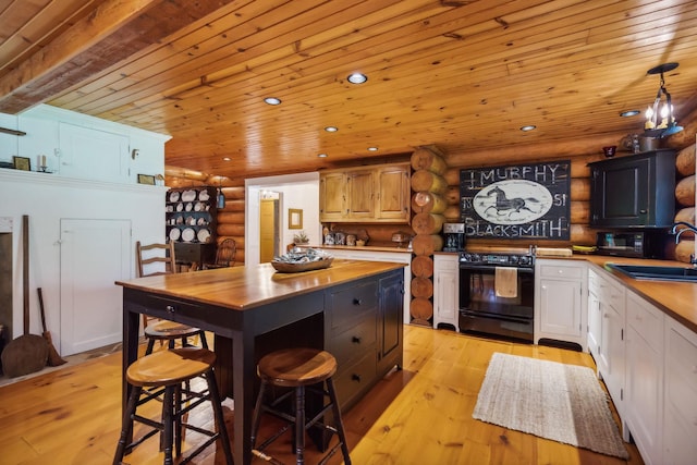 kitchen with a sink, light wood-style floors, butcher block countertops, and black electric range oven