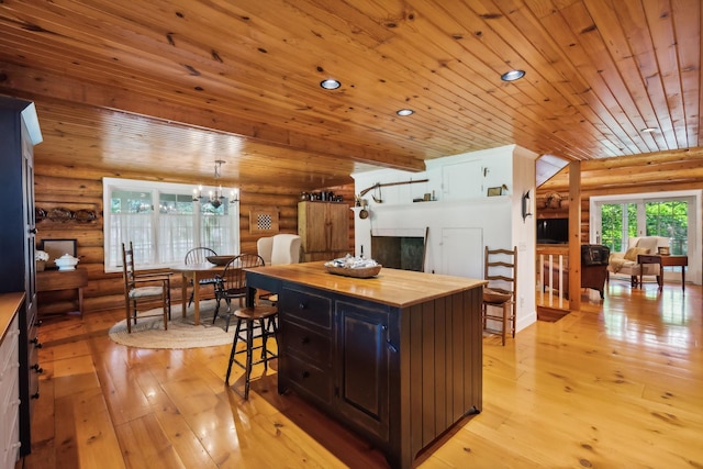 kitchen with light wood finished floors, wood ceiling, butcher block countertops, a breakfast bar, and recessed lighting