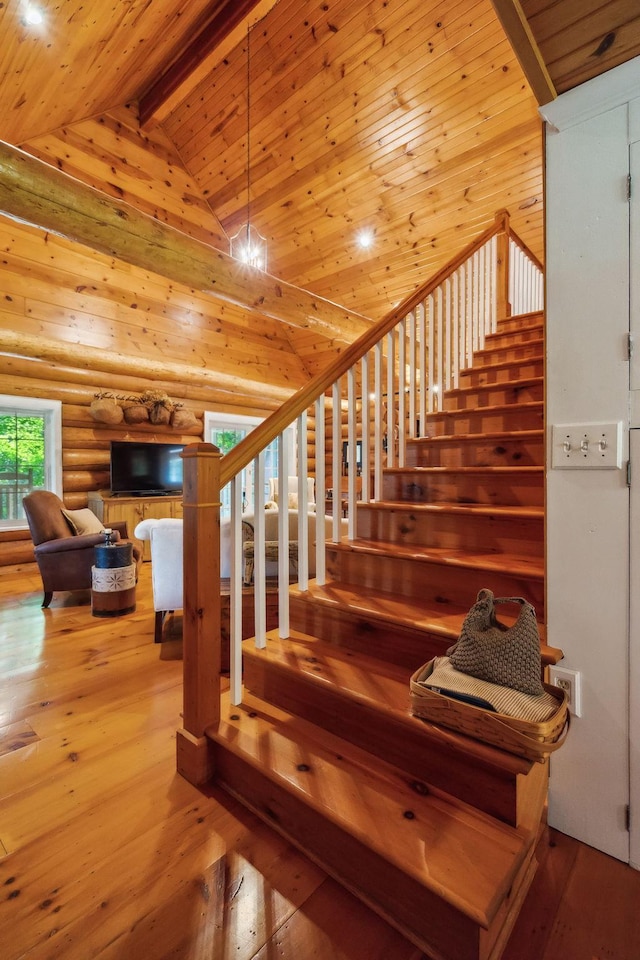 stairs featuring high vaulted ceiling, wooden ceiling, beam ceiling, log walls, and hardwood / wood-style floors