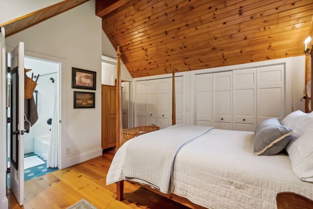 bedroom with vaulted ceiling with beams, multiple closets, light wood-type flooring, wooden ceiling, and baseboards