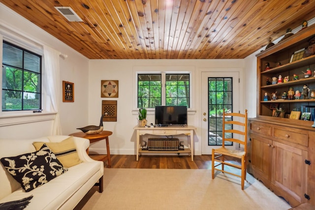 living area featuring wood ceiling, visible vents, baseboards, and wood finished floors