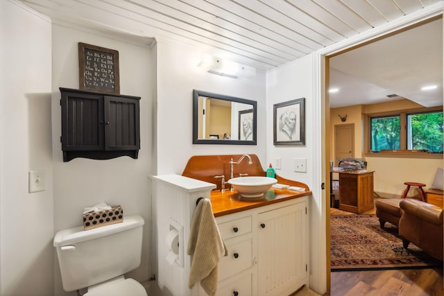 bathroom with wood ceiling, vanity, wood finished floors, and toilet