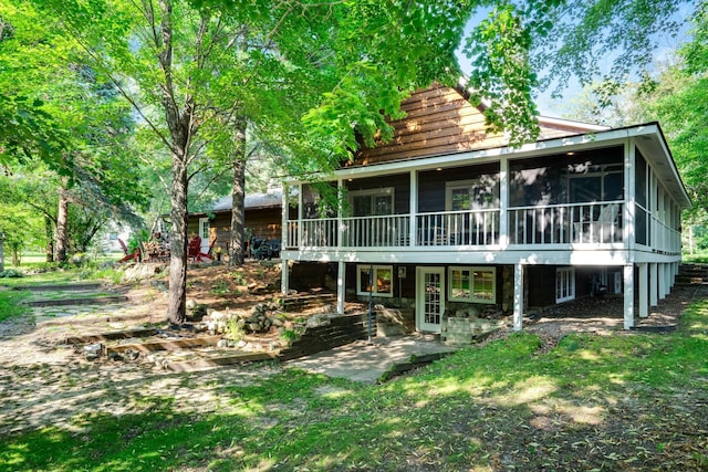 rear view of house featuring a sunroom and a patio