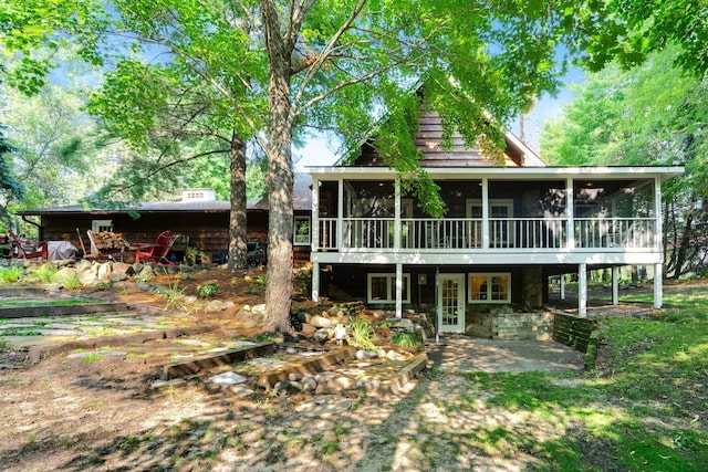 rear view of property featuring a sunroom and a patio area