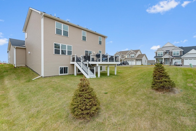 rear view of property with a residential view, a yard, a wooden deck, and stairs