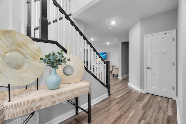 entryway with baseboards, stairway, wood finished floors, and recessed lighting