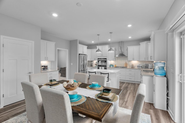 dining room with light wood-type flooring, a toaster, and recessed lighting