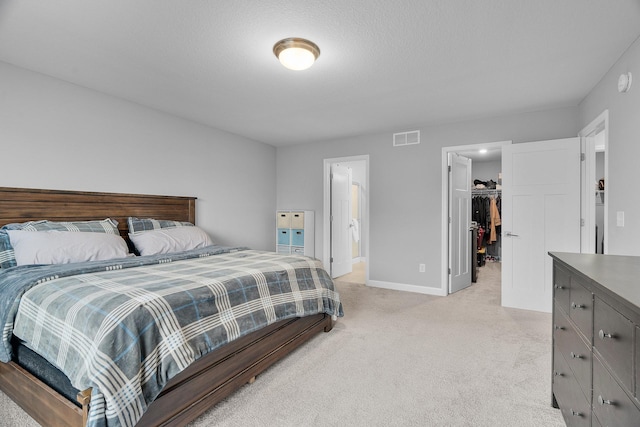 bedroom with light carpet, baseboards, visible vents, a spacious closet, and a closet