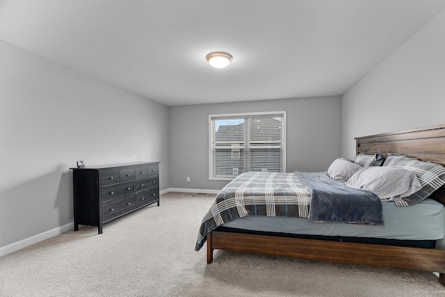 bedroom with baseboards and light colored carpet